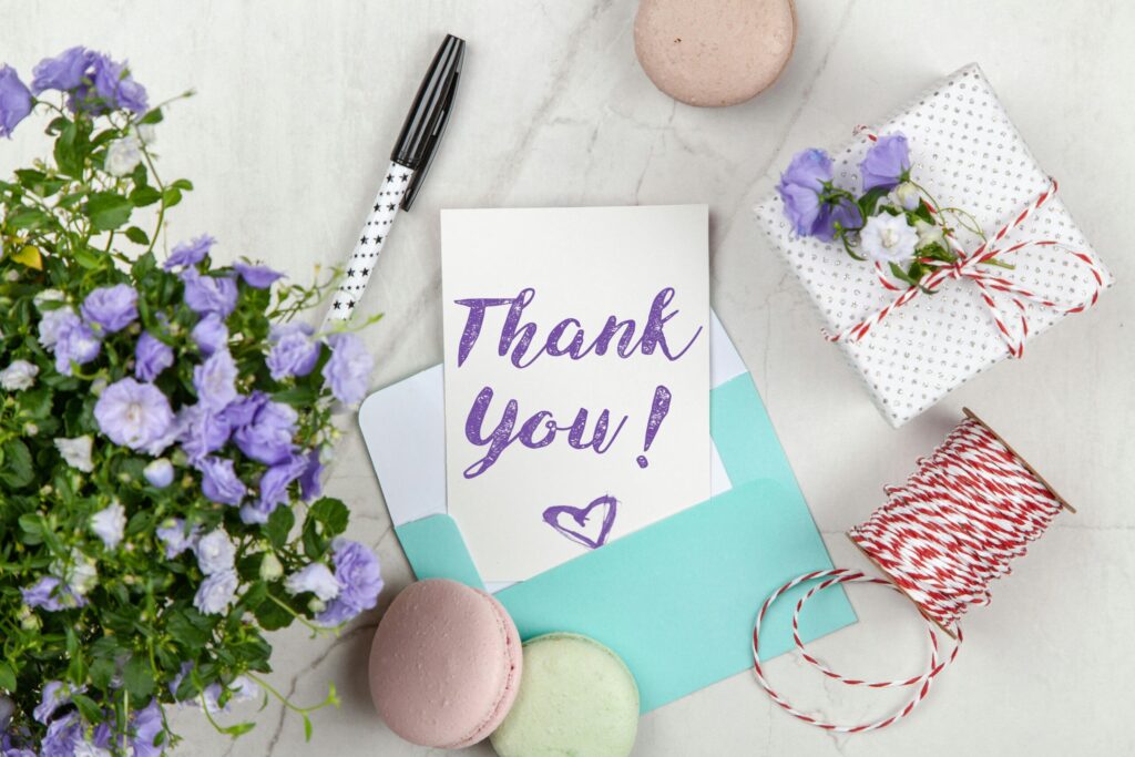 pexels-photo-2072168-2072168 A beautifully arranged thank you card with lavender flowers, macarons, and gift package on a marble desk.